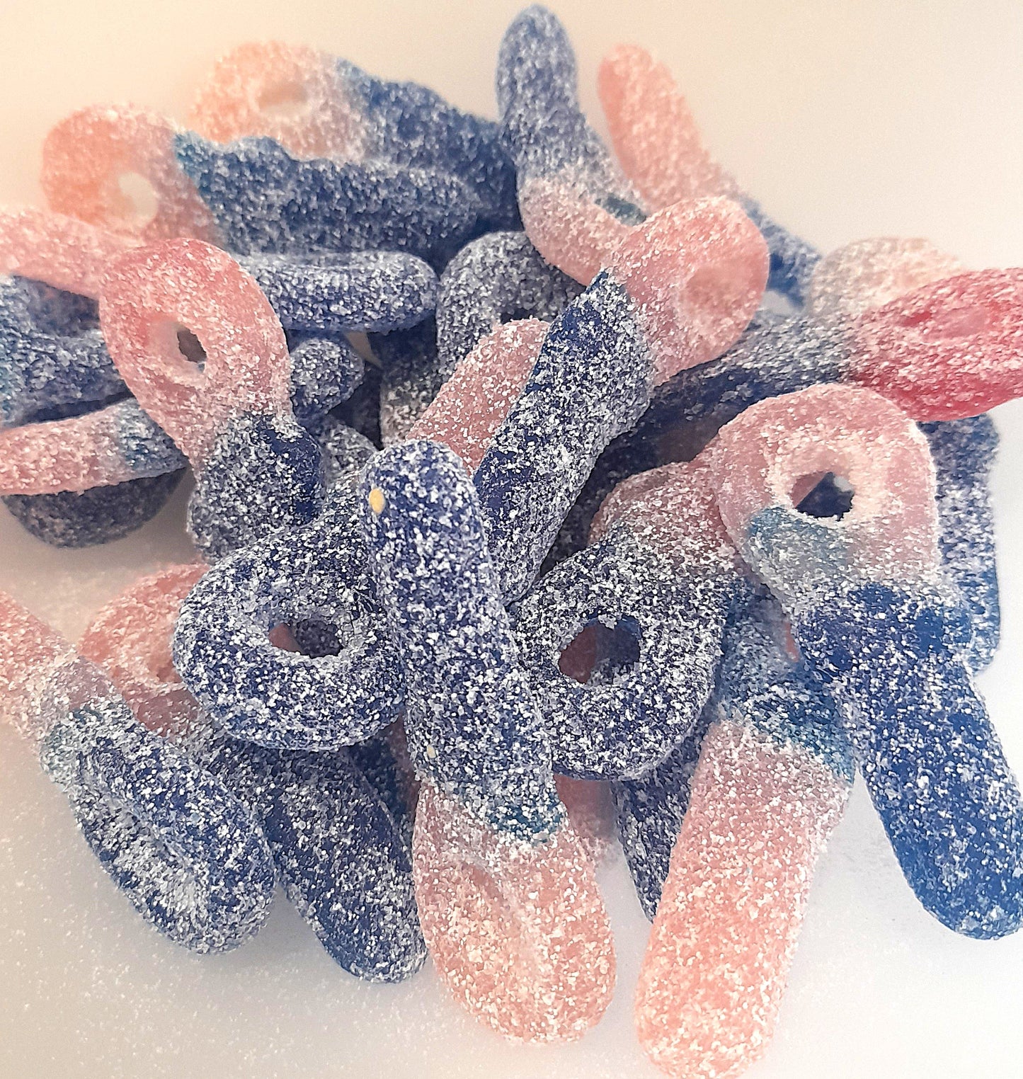 A group of fizzy bubblegum tongue painting dummies, with a mix of pink and blue colors on a white background.