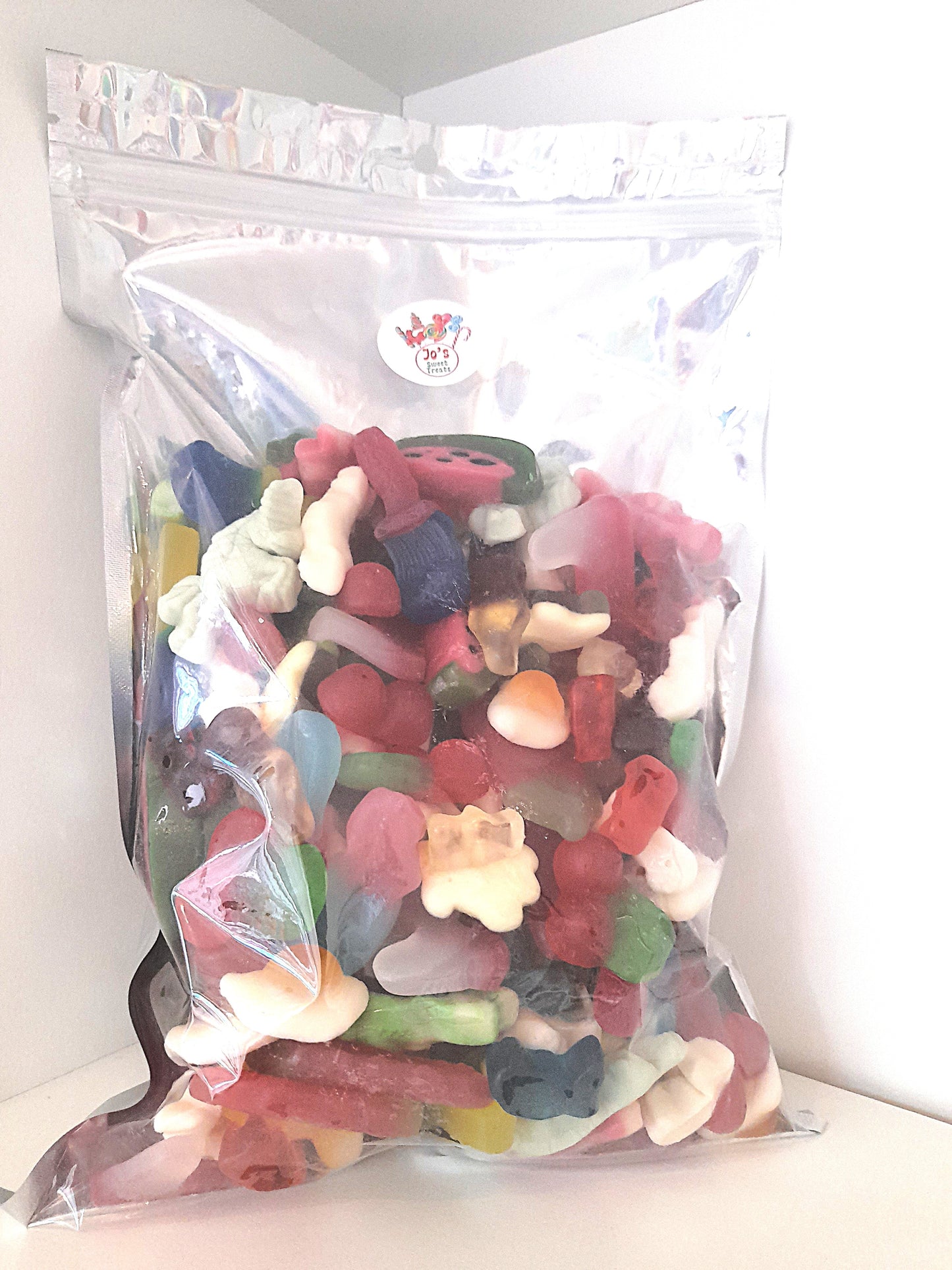 A clear plastic bag filled with colorful fruit-flavored jelly sweets, with brands and flavors visible.