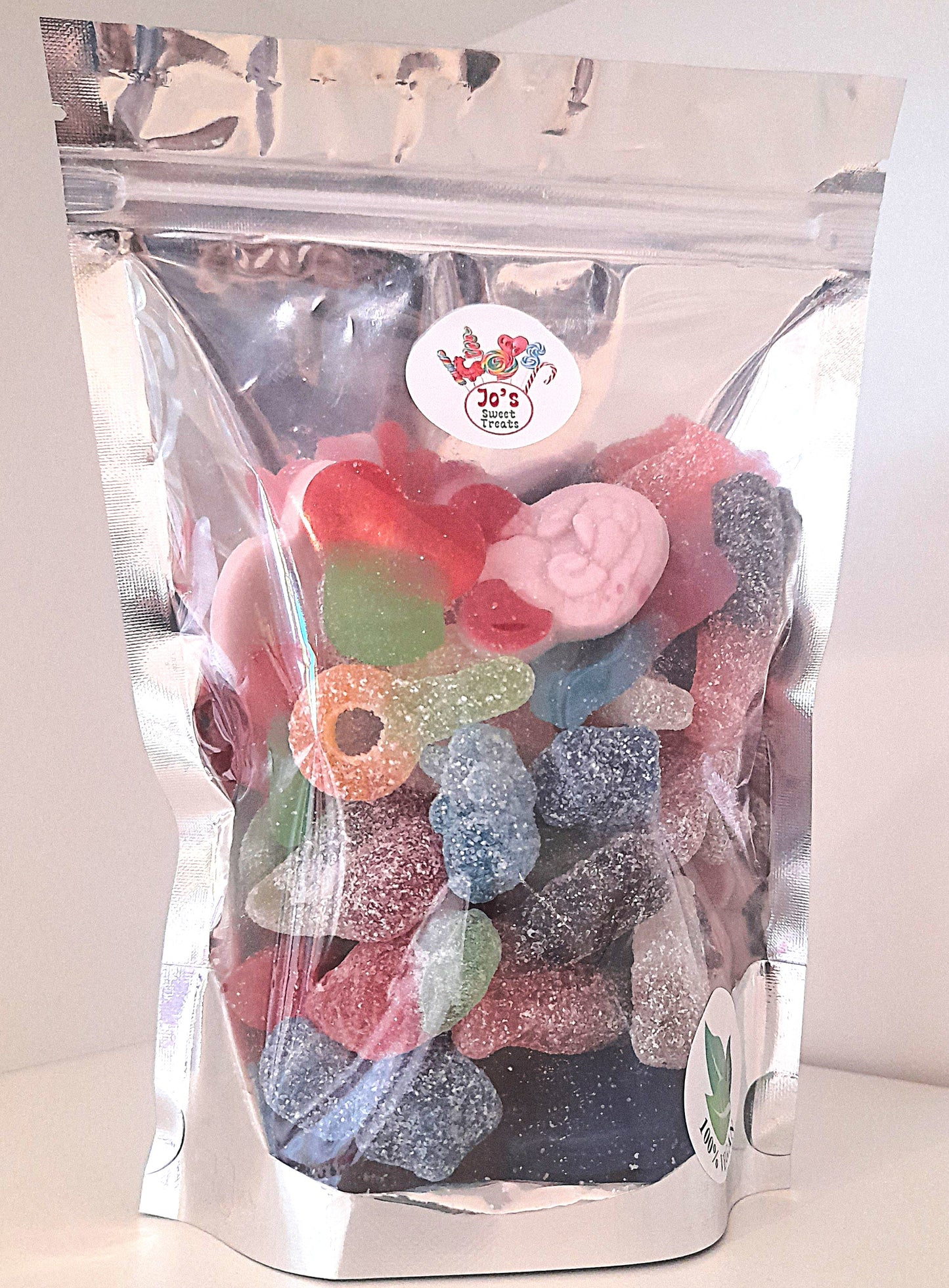 A clear plastic pouch filled with various candies, sealed with a label that reads 'VEGAN MIX'.