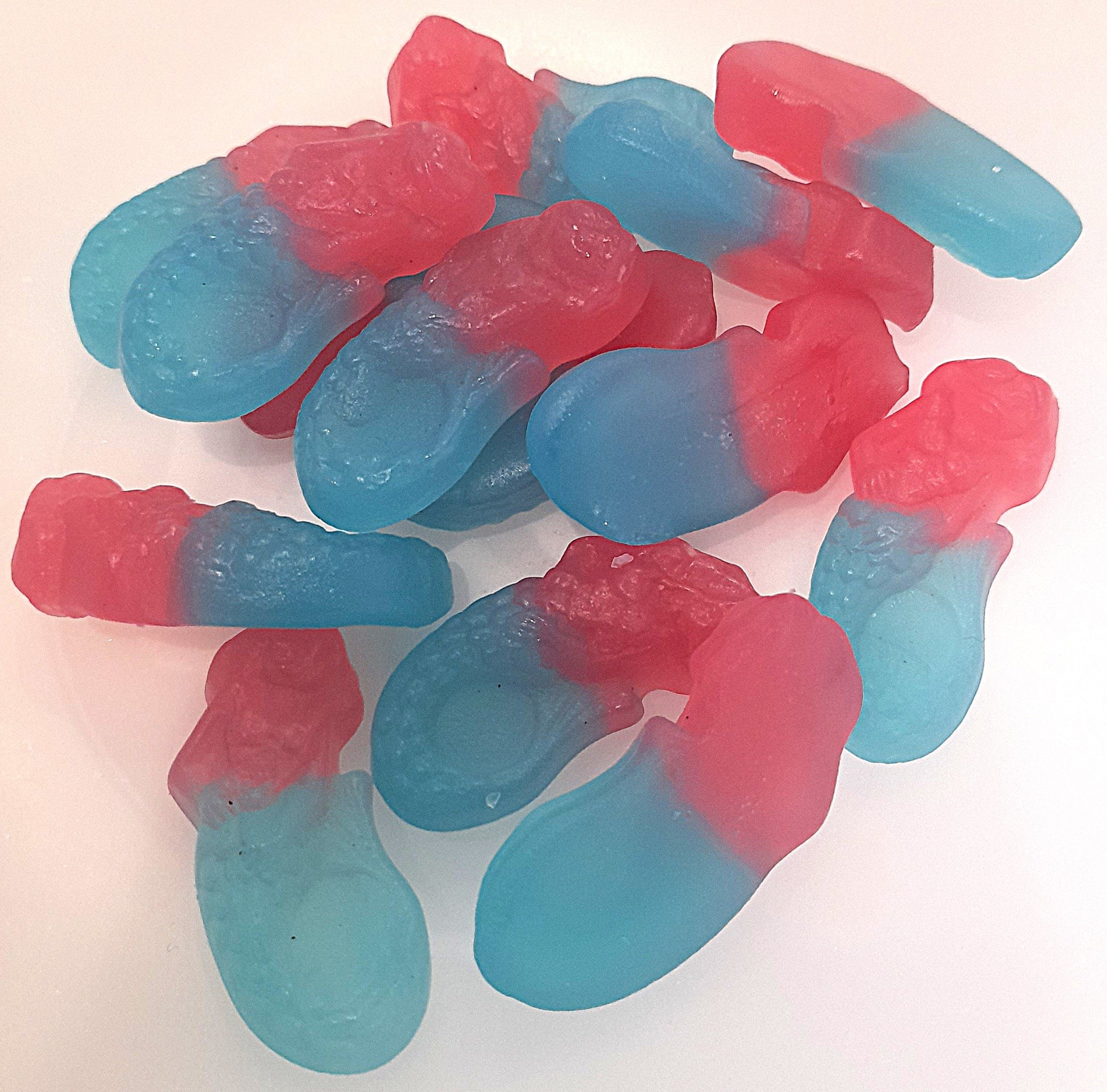 A group of bubblegum flavored gummy sweets shaped like mermaids, with a mix of pink and blue colors.