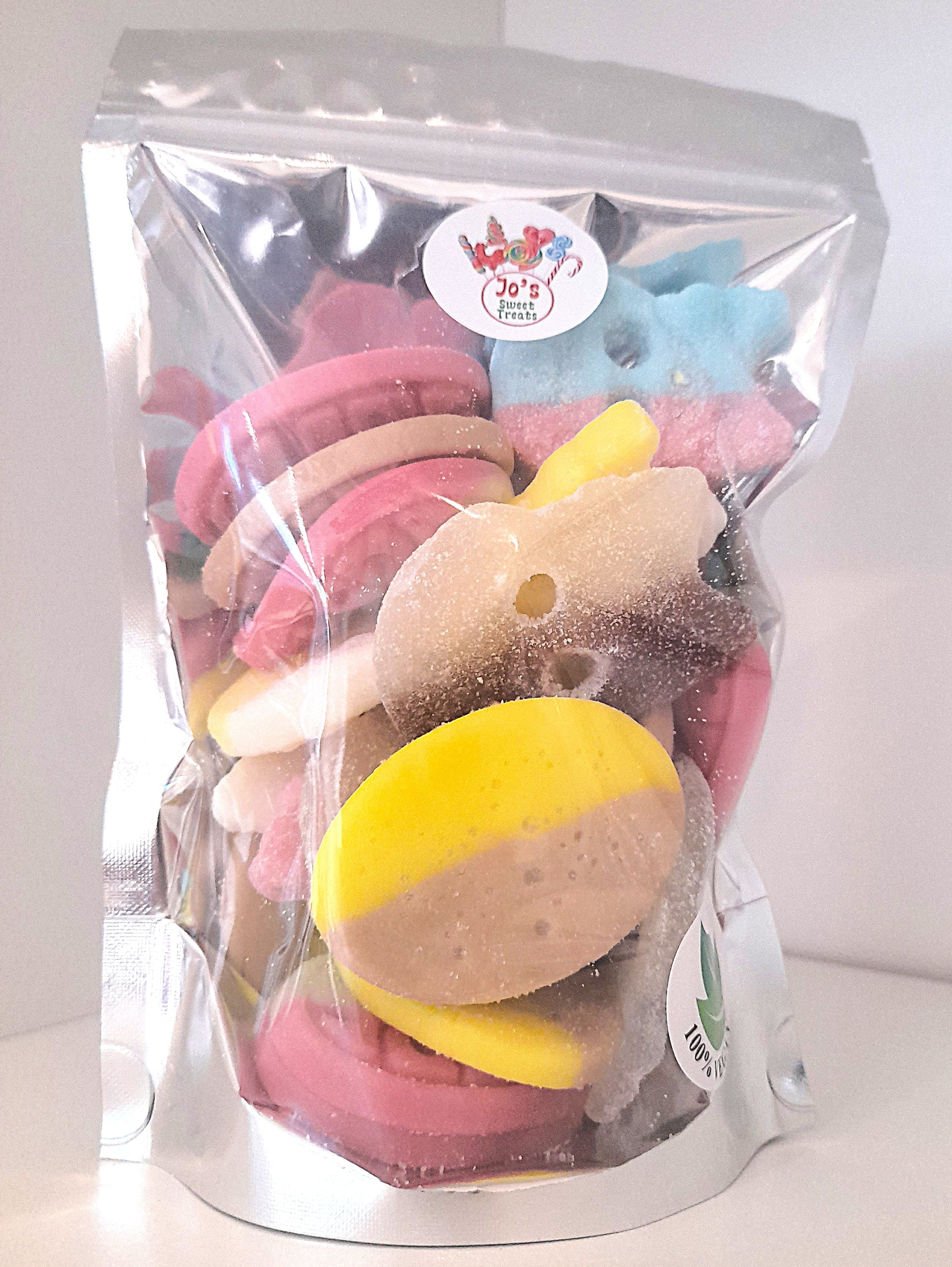 A clear plastic pouch filled with various candies and cookie pieces, labeled 'BUBS' and 'Vegan'.