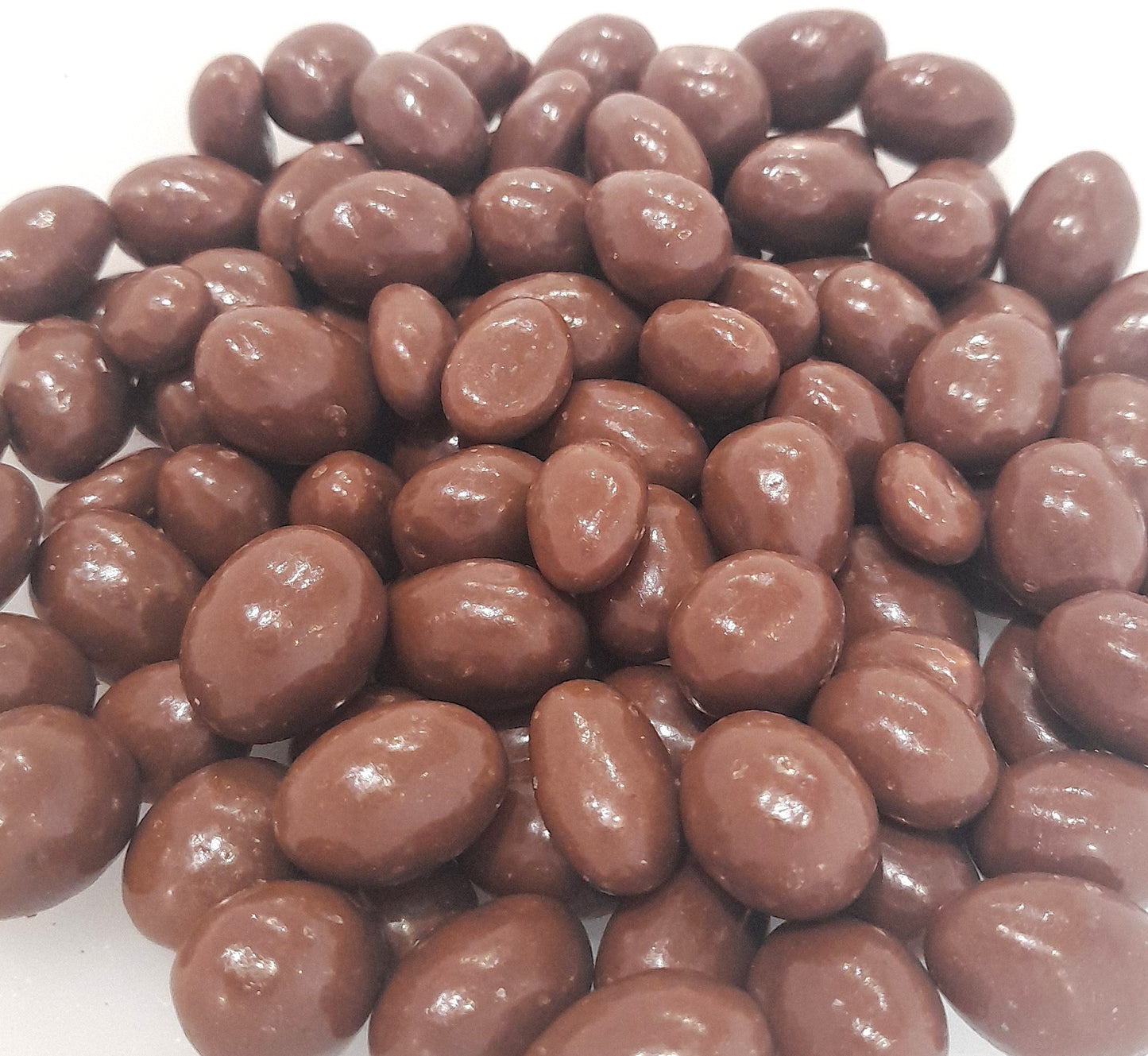 A group of milk chocolate covered peanuts on a white background.