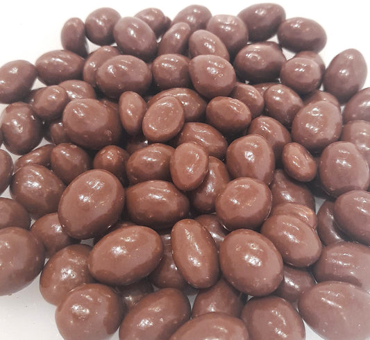 A group of milk chocolate covered peanuts on a white background.
