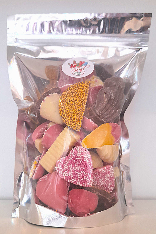A pouch of chocolate mix with various shapes of chocolate pieces visible through the transparent packaging.
