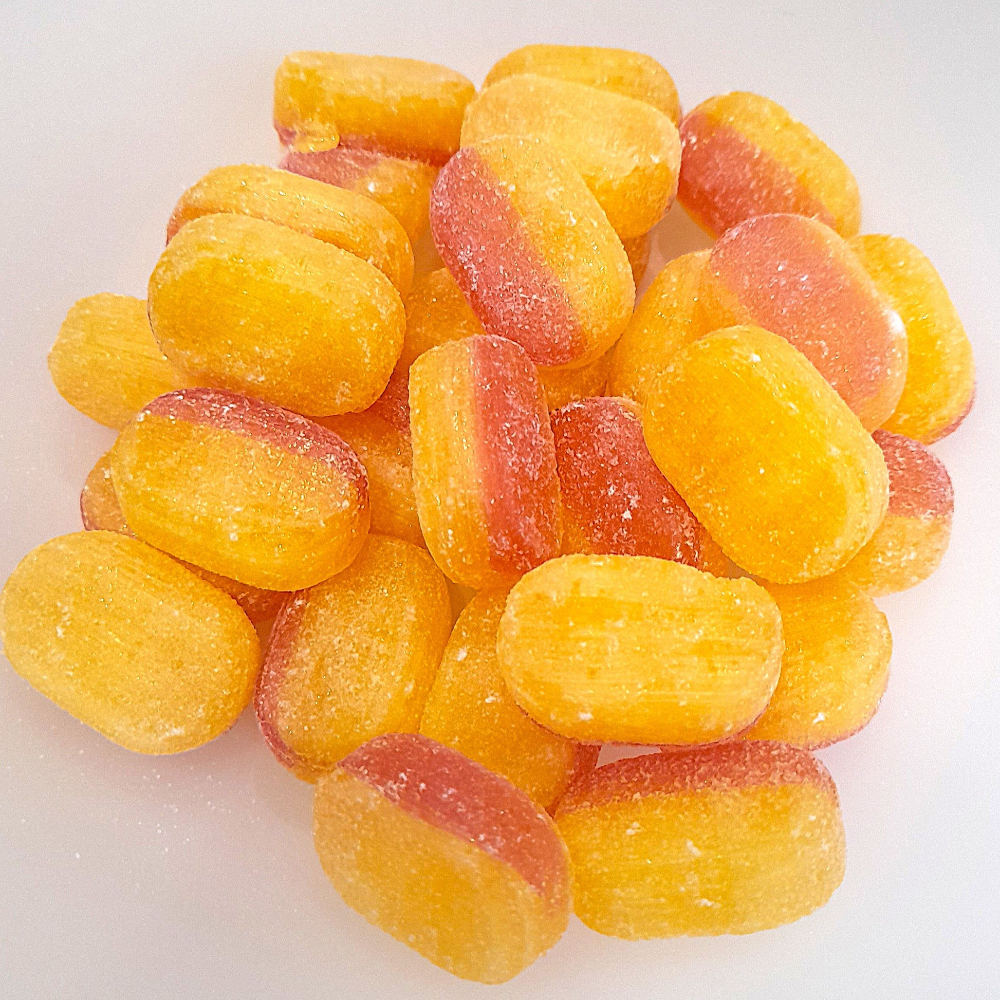 A pile of rhubarb and custard flavored candies, with a mix of yellow and pink colors.