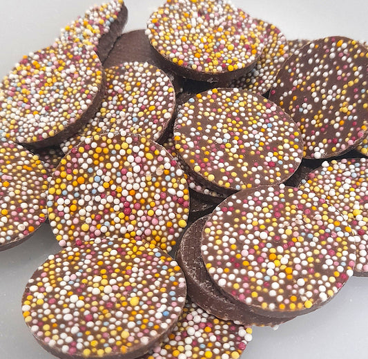Decorated milk chocolate flavored chocolate disks with tiny hundreds and thousands on top, resembling a classic novelty sweet.