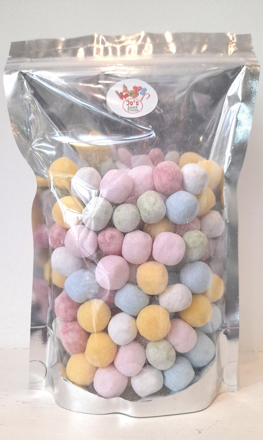 A clear plastic packaging filled with colorful, round, sugar-coated candy pieces.