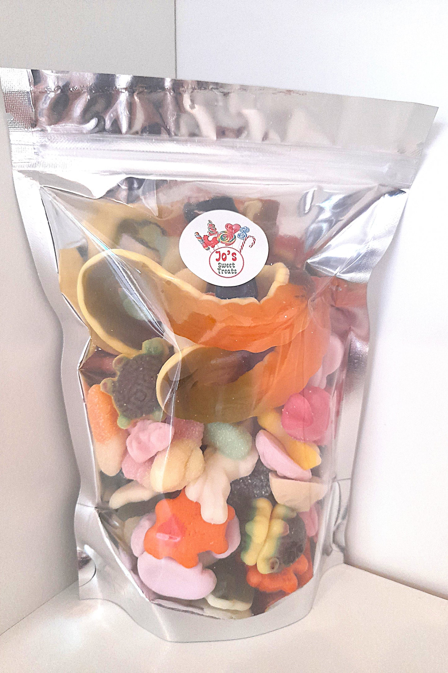 A clear plastic pouch filled with various candies, sealed with a label showing the brand and product name.