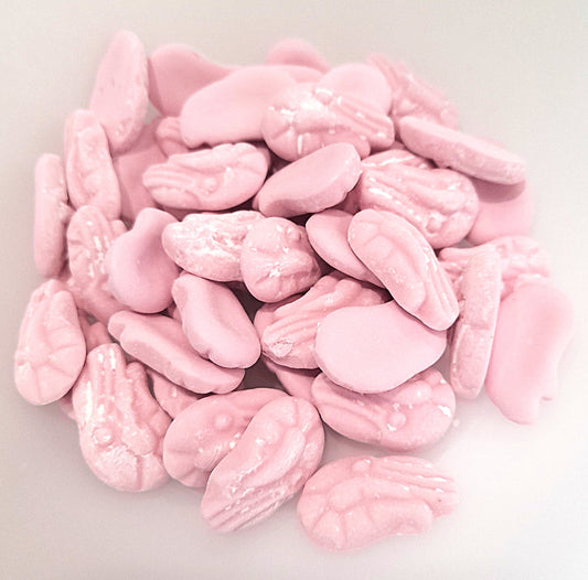 A pile of pink foam shrimp candies on a light background.