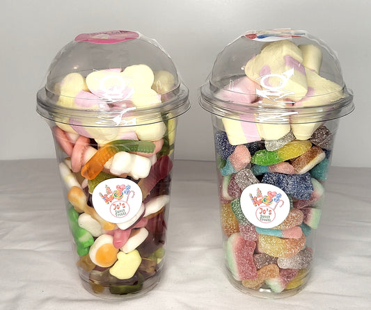 Two clear plastic cups filled with a variety of colorful candy and sweets, with domed lids.